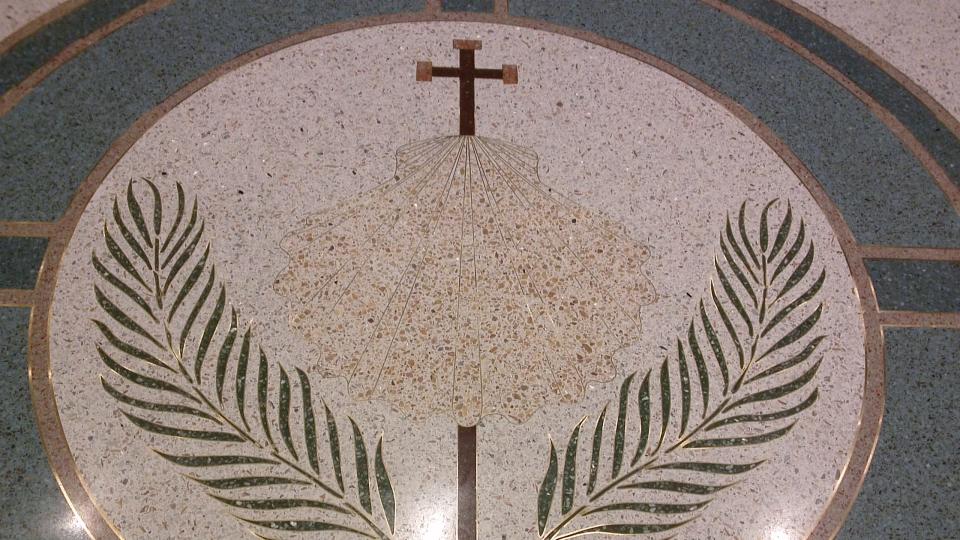 A Terrazzo tile in the front gathering space at St. James church. It shows the symbol of St. James, a scallop shell.