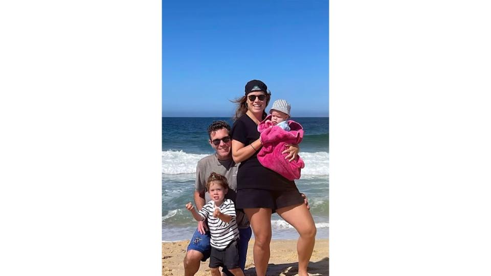 Princess Eugenie holding back Ernest while standing with Jack Brooksbank and son August