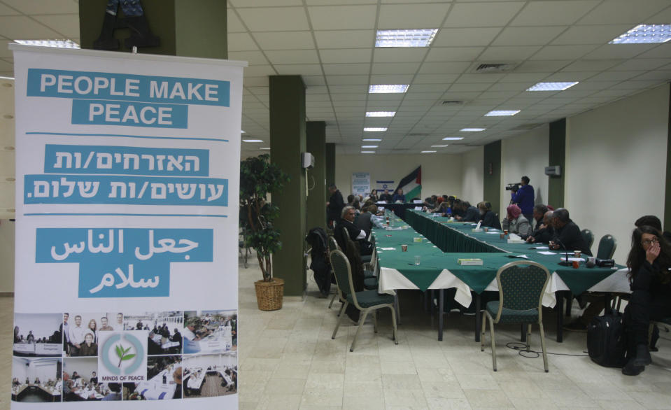 The Israeli delegation, center on photo, and the Palestinians delegation hold a meeting in the West Bank city of Ramallah, Thursday, Jan. 9, 2014. Palestinians threw rocks Thursday at a West Bank hotel, shattering windows and breaking up a meeting of Israeli and Palestinian peace activists. (AP Photo/Majdi Mohammed)