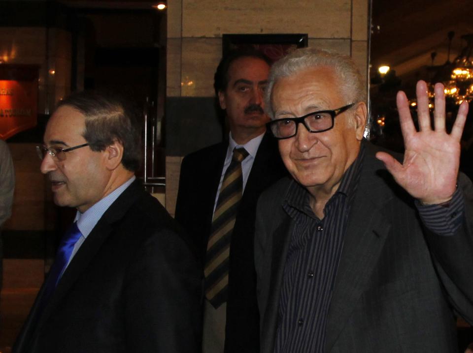 United Nations Peace Envoy for Syria Lakhdar Brahimi (R) waves to journalists during his arrival at a hotel in Damascus October 28, 2013. Seen at left is Syria's Deputy Foreign Minister Faisal al-Miqdad. REUTERS/Khaled al-Hariri (SYRIA - Tags: POLITICS CONFLICT CIVIL UNREST)
