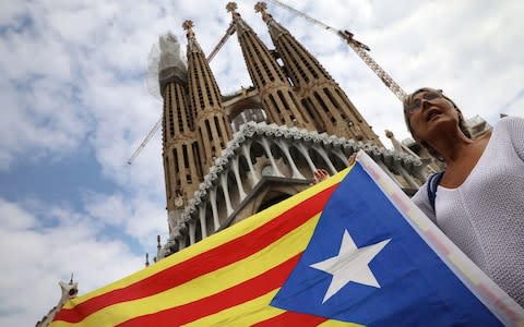 A Catalonian flag held aloft outside the Sagrada Familia - Credit: Getty