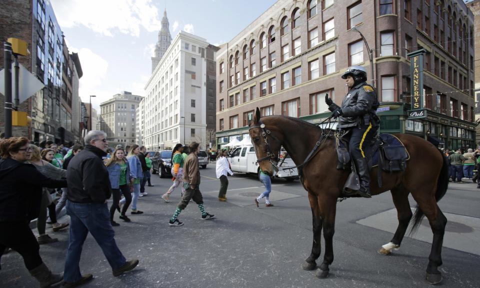 A Cleveland Police Mounted Unit patrolman directs pedestrians in downtown Cleveland on March 17, 2016. (Photo: Tony Dejak/AP)