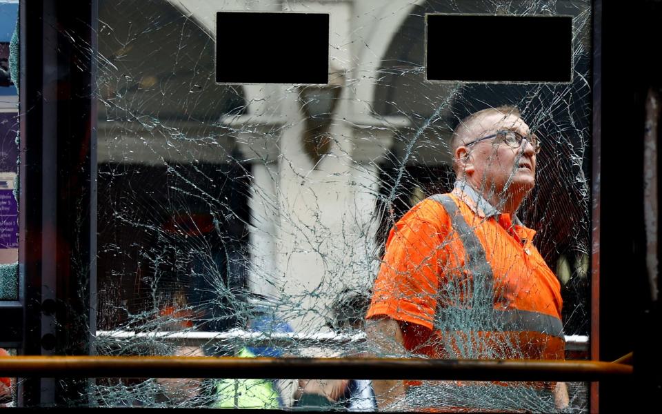 A worker inspects a tram damaged in the riot