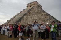 People gather in front of the Kukulkan temple in Chichen Itza, Mexico, Friday, Dec. 21, 2012. Ceremonial fires burned and conches sounded off as dawn broke over the steps of the main pyramid at the Mayan ruins of Chichen Itza Friday, making what many believe is the conclusion of a vast, 5,125-year cycle in the Mayan calendar. Some have interpreted the prophetic moment as the end of the world. The hundreds gathered in the ancient Mayan city, however, said they believed it marked the birth of a new and better age. (AP Photo/Israel Leal)