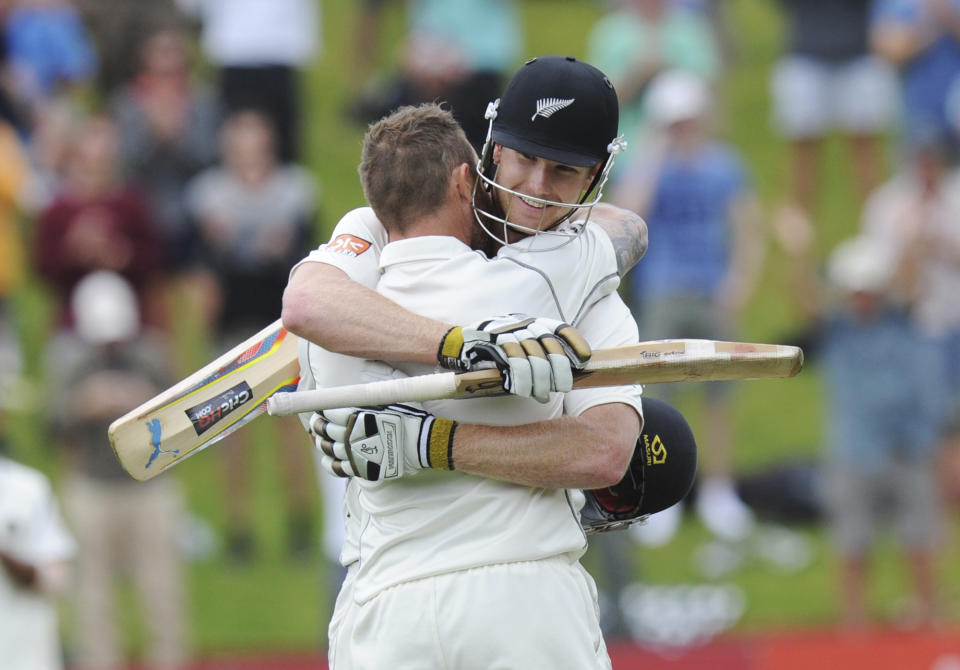 New Zealand’s Brendon McCullum, left, is hugged by James Neesham on reaching New Zealander's highest score in tests, on the final day of the second test against India at the Basin Reserve in Wellington, New Zealand, Tuesday, Feb. 18, 2014. (AP Photo/SNPA, Ross Setford) NEW ZEALAND OUT