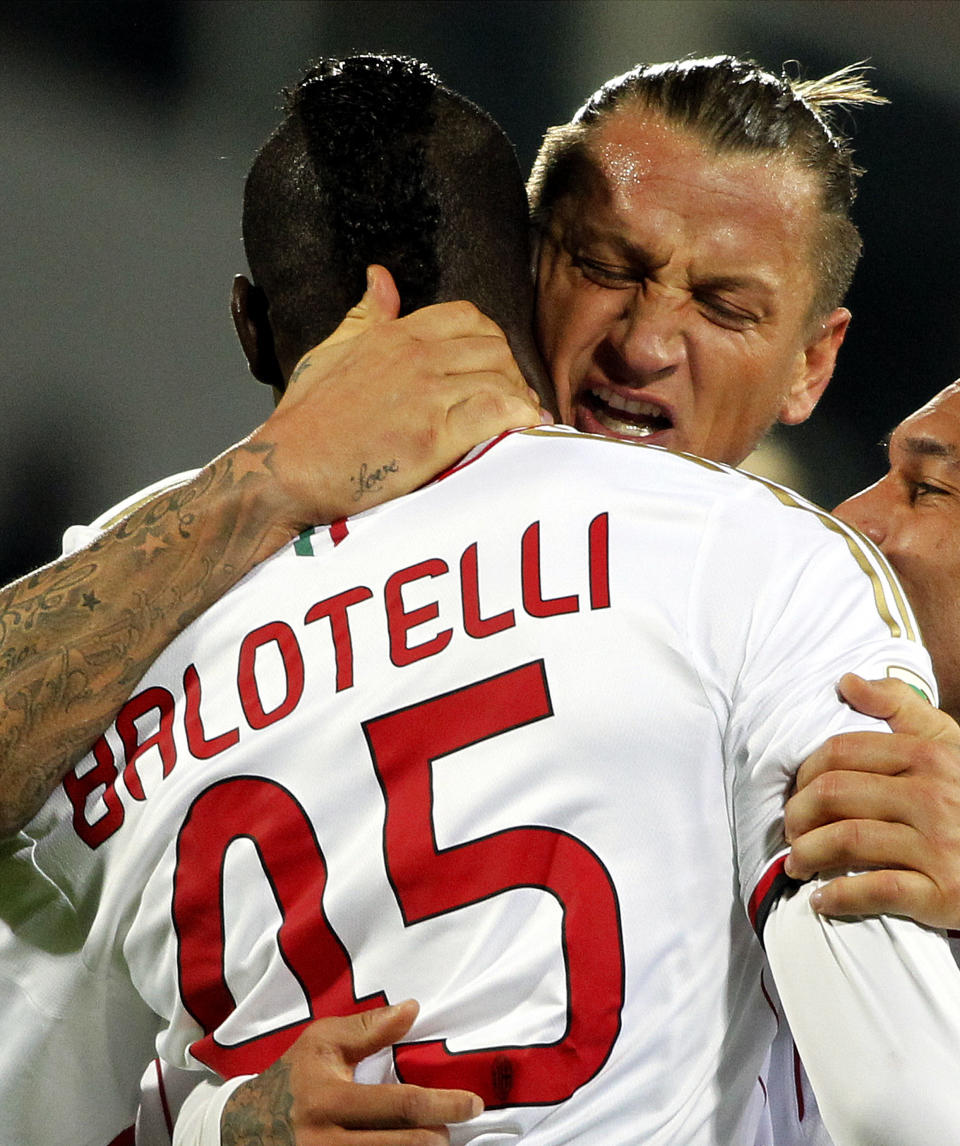 AC Milan's Mario Balotelli, left, is cheered by teammate Philippe Mexes after scoring during a Serie A soccer match between Fiorentina and AC Milan at the Artemio Franchi stadium in Florence, Italy, Wednesday March 26, 2014. (AP Photo/Fabrizio Giovannozzi)