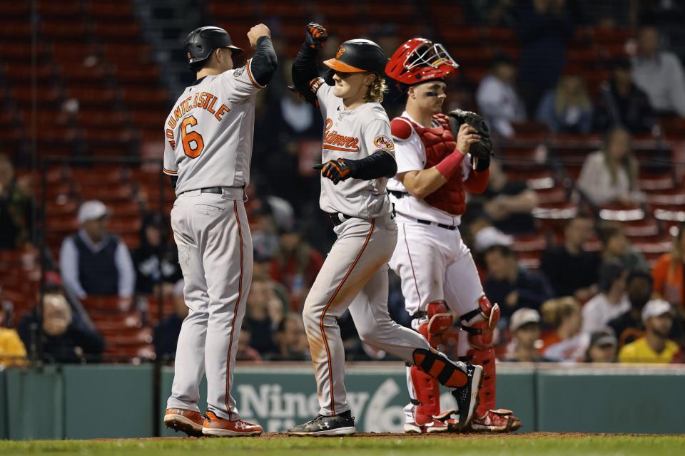 Baltimore Orioles' Gunnar Henderson, center, celebrates after his two-run home run in front of Boston Red Sox's Reese McGuire, right, that also drove in Ryan Mountcastle (6) during the sixth inning of a baseball game, Monday, Sept. 26, 2022, in Boston. (AP Photo/Michael Dwyer)