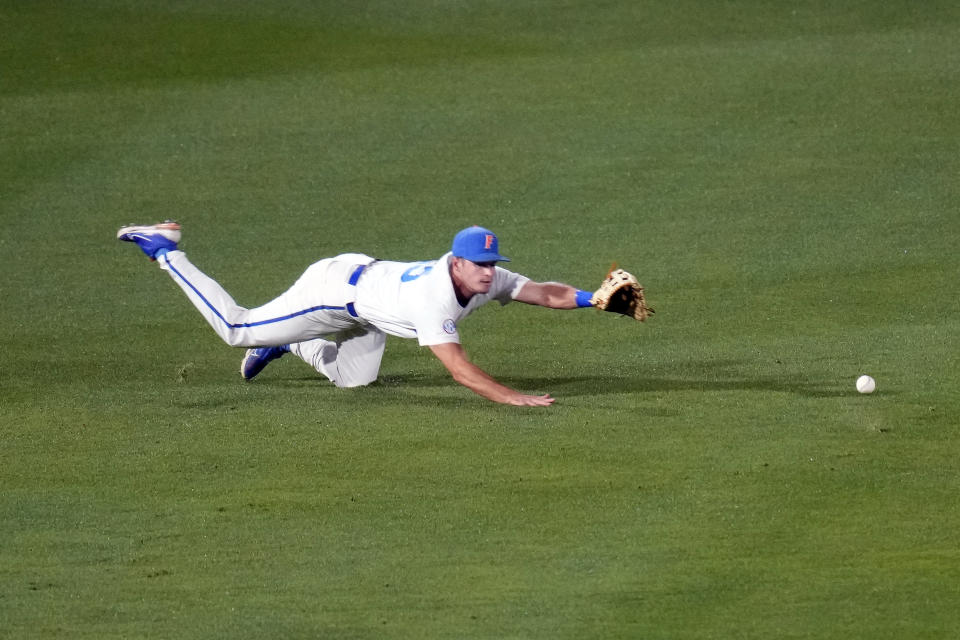 Florida outfielder Richie Schiekofer dives for the ball but is unable to catch a hit by South Carolina's Will McGillis during the second inning of an NCAA college baseball tournament super regional game Friday, June 9, 2023, in Gainesville, Fla. (AP Photo/John Raoux)