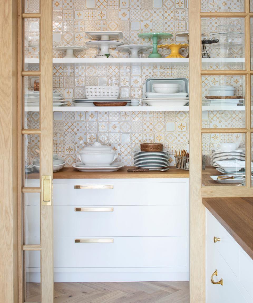 Orange and white tiles, white shelves, wooden and glass doors, white drawers
