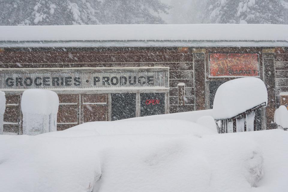 Snow covers the landscape in front of a store, during a storm, Saturday, March 2, 2024, in Truckee, California.