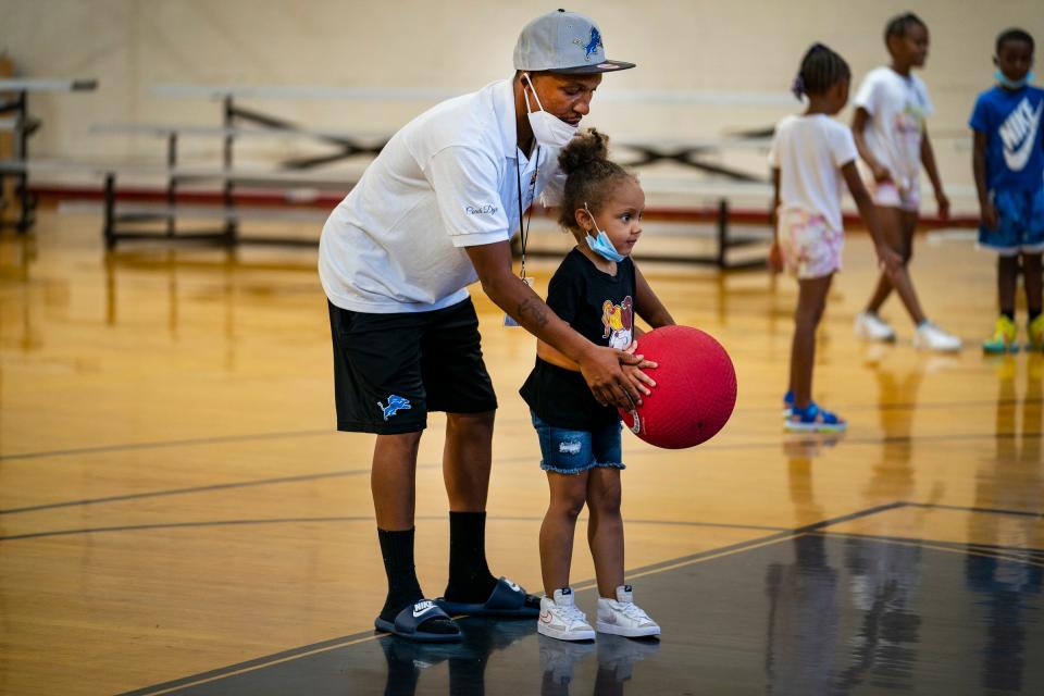 Steven Dye II, director of operations of Detroit Magic Child Development Summer Enrichment Madness, works with Khijah Jackson, 4, of Detroit as his students participate in a kickball game in the gymnasium of their facility in Detroit on July 14, 2022. The organization is one of fifteen in Michigan accepted into phase two of "A Community Thrives" grant program by Gannett.