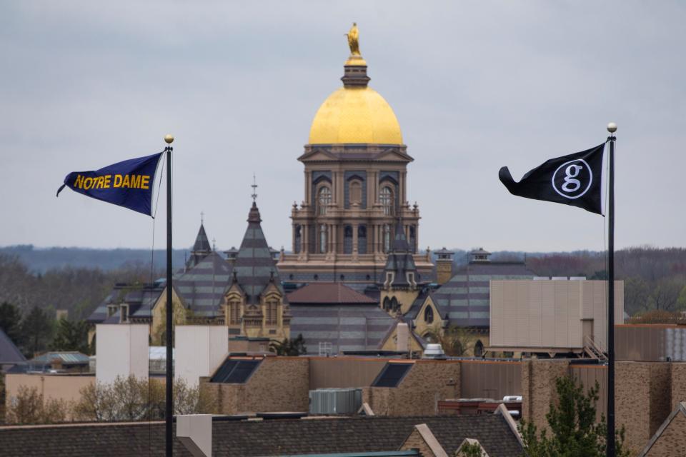 The Notre Dame and Garth Brooks flags fly as the administration building's golden dome can be seen in the background Friday at Notre Dame Stadium in South Bend.