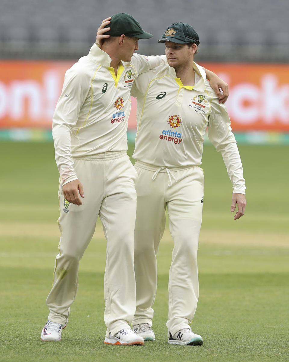 Australia's Marnus Labuschagne, left, and teammate Steve Smith embrace as they walk from the field at the close of play on the second day of the first cricket test between Australia and the West Indies in Perth, Australia, Thursday, Dec. 1, 2022. (AP Photo/Gary Day)