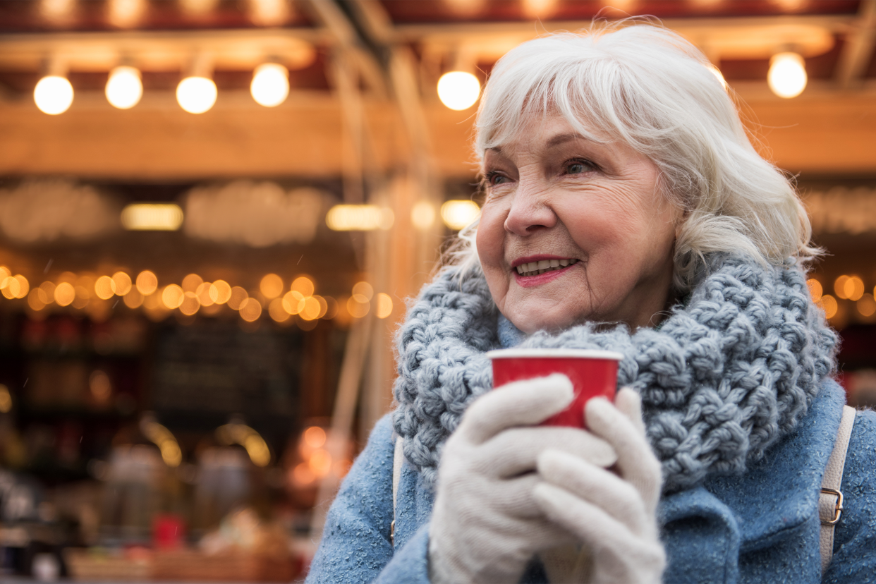 Senior woman drinking outside in the winter