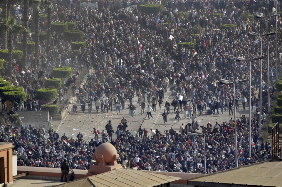 FILE - In this Feb. 2, 2011 file photo, pro-government demonstrators, below, clash with anti-government demonstrators, above, as an Egyptian Army soldier on the rooftop of the Egyptian Museum observes the scene in Tahrir square, the center of anti-government demonstrations, in Cairo, Egypt. Ten years ago, an uprising in Tunisia opened the way for a wave of popular revolts against authoritarian rulers across the Middle East known as the Arab Spring. For a brief window as leaders fell, it seemed the move toward greater democracy was irreversible. Instead, the region saw its most destructive decade of the modern era. Syria, Yemen, Libya and Iraq have been torn apart by wars, displacement and humanitarian crisis. (AP Photo/Ben Curtis, File)