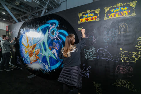 In this photo provided by Nintendo of America, Shaylyn D. is added to the Pokémon Scarlet and Pokémon Violet-themed murals at PAX East.