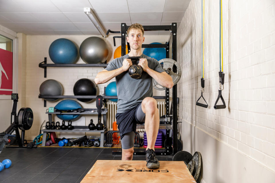 Male cyclist using a kettlebell as part of strengthening exercises off the bike