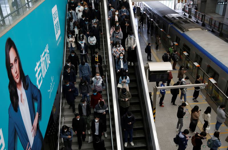 People wearing face masks are seen inside a subway station during morning rush hour in Beijing