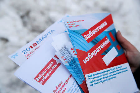 An activist and supporter of Russian opposition leader Alexei Navalny holds fliers while walking through a housing estate to promote a boycott of the upcoming presidential election in Moscow, Russia February 10, 2018. Picture taken February 10, 2018. REUTERS/Maxim Shemetov
