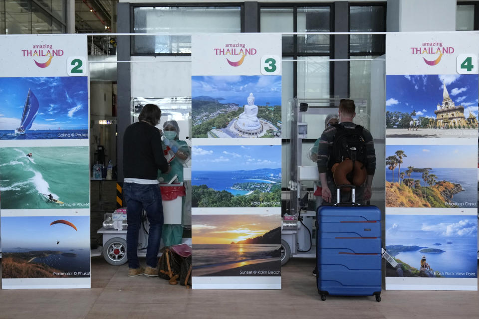 The first group tourist are tested for the COVID-19 after arriving at the Phuket International Airport in Phuket, Thailand, Thursday, July 1, 2021. Starting Thursday, Thailand will welcome back international visitors — as long as they are vaccinated — to its famous southern resort island of Phuket without having to be cooped up in a hotel room for a 14-day quarantine. (AP Photo/Sakchai Lalit)