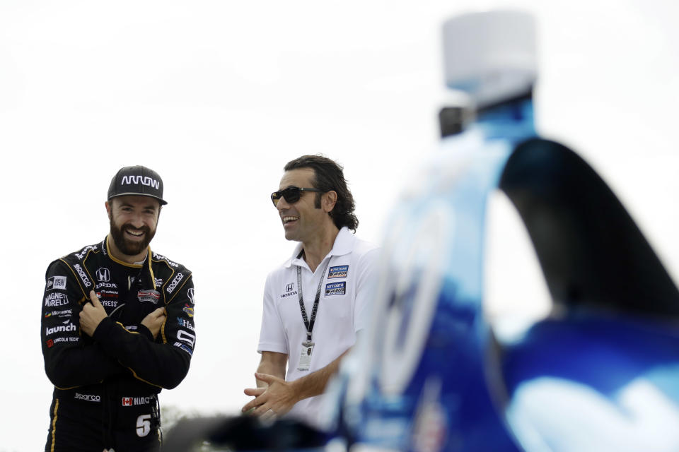 James Hinchcliffe, left, and Dario Franchitti talk before a practice session for Sunday's IndyCar series auto race, Saturday, Aug. 18, 2018, in Long Pond, Pa. (AP Photo/Matt Slocum)