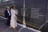 FILE - Ronit Naibryf, right, shows Miami-Dade County Mayor Daniella Levina Cava, the name of her son Ilan Naibryf, Thursday, May 12, 2022, in Surfside, Fla., on a large banner with the names of the 98 people killed in the collapse of the Champlain Towers South condominium. Attorneys for the families who lost relatives or homes in last year’s collapse of a Florida condominium tower that killed 98 people finalized a $1 billion settlement on Friday, May 27, 2022. (AP Photo/Marta Lavandier, File)