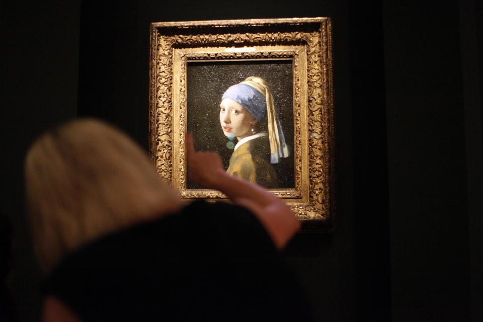 This June 19, 2013 photo shows Johannes Vermeer’s famous painting "Girl With a Pearl Earring" part of the "Girl with a Pearl Earring: Dutch Paintings from the Mauritshuis" exhibit during a media preview at the High Museum of Art in Atlanta. The exhibit, which opens Sunday and runs through Sept. 29, includes 34 other works from the Dutch Golden Age. (AP Photo/Jaime Henry-White)