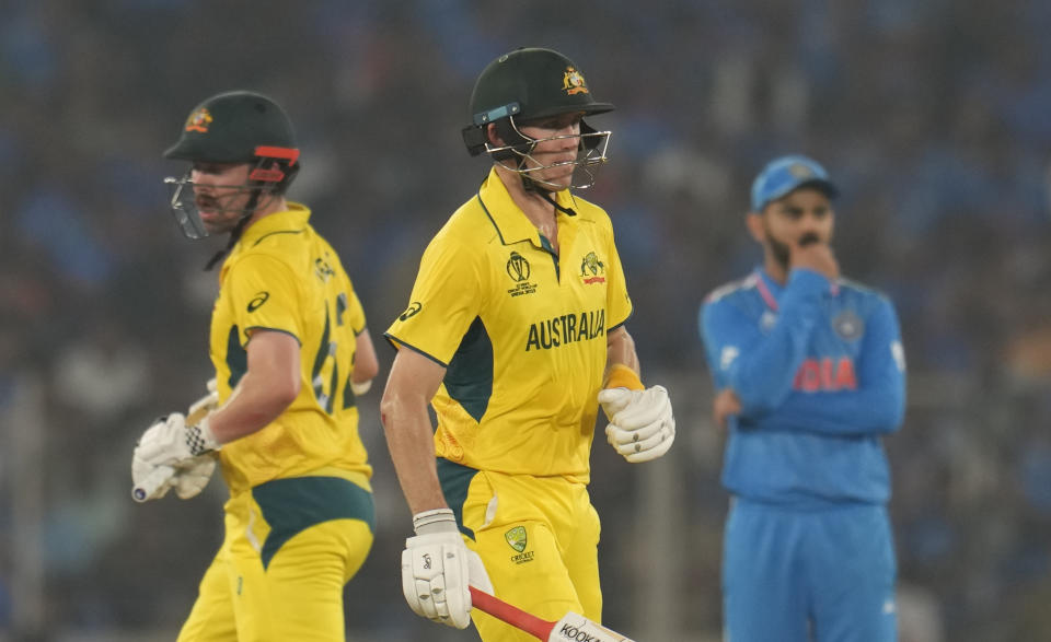 Australia's Marnus Labuschagne and Australia's Travis Head run between the wickets as India's Virat Kohli, right, watches during the ICC Men's Cricket World Cup final match between India and Australia in Ahmedabad, India, Sunday, Nov.19, 2023. (AP Photo/Aijaz Rahi)