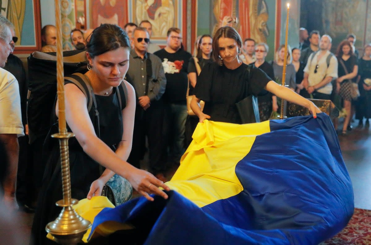 Mourners cover the coffin of Victoria Amelina at St. Mykhailivsky Cathedral in Kyiv on Tuesday (EPA)