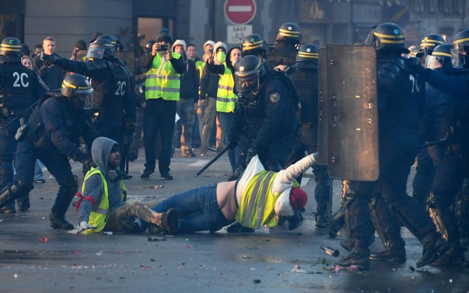 Yellow vest demonstrators are evacuated by policemen in Quimper, western France, in November 2018 - FRED TANNEAU/AFP