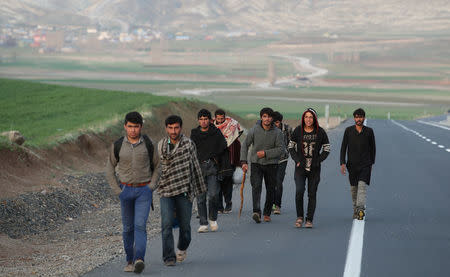 A group of Afghan migrants walk along a main road after crossing the Turkey-Iran border near Dogubayazit, Agri province, eastern Turkey, April 11, 2018. Picture taken April 11, 2018. REUTERS/Umit Bektas