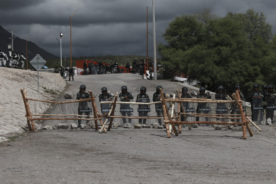 National Guard troops equipped with riot gear stand guard at Las Pilas dam, two days after withdrawing from nearby La Boquilla dam after clashing with hundreds of farmers, in Camargo, Chihuahua State, Mexico, Thursday, Sept. 10, 2020. President Andrés Manuel López Obrador said Thursday he regretted the killing of a woman and the wounding of her husband following a Tuesday clash between National Guard troops and farmers over water. (AP Photo Christian Chavez)