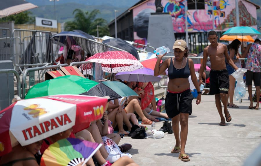 Street vendors sell bottled water to Taylor Swift fans amid a heat wave before her Eras Tour concert outside the Nilton Santos Olympic stadium in Rio de Janeiro, Brazil, Saturday, Nov. 18, 2023. A 23-year-old Taylor Swift fan died at the singer’s Eras Tour concert in Rio de Janeiro Friday night, according to a statement from the show’s organizers in Brazil. Both Swifties and politicians reacted to the news with outrage. While a cause of death for Ana Clara Benevides Machado has not been announced, fans complained they were not allowed to take water into Nilton Santos Olympic Stadium despite soaring temperatures. (AP Photo/Silvia Izquierdo)