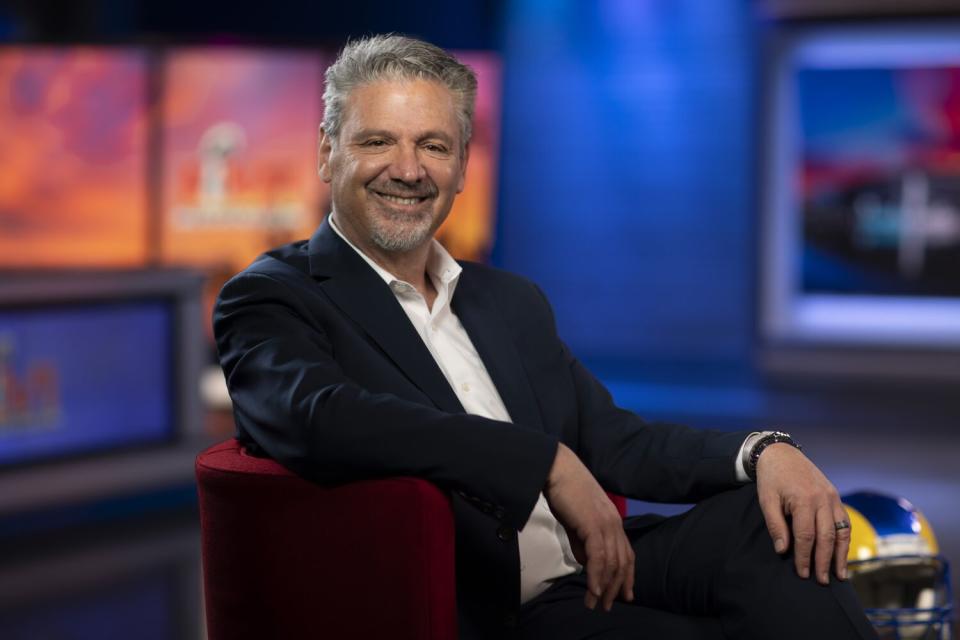 Fred Roggin sits inside a TV studio.