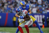 Los Angeles Rams' Cooper Kupp, right, tackles New York Giants' Xavier McKinney after McKinney intercepted a pass during the first half of an NFL football game, Sunday, Oct. 17, 2021, in East Rutherford, N.J. (AP Photo/John Munson)