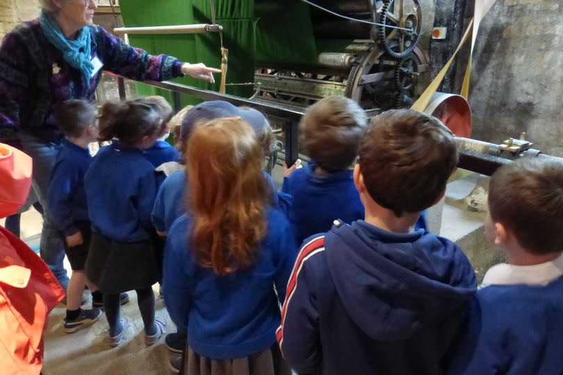 Jane Ford showing schoolchildren the working practices inside Dunkirk Mill Museum