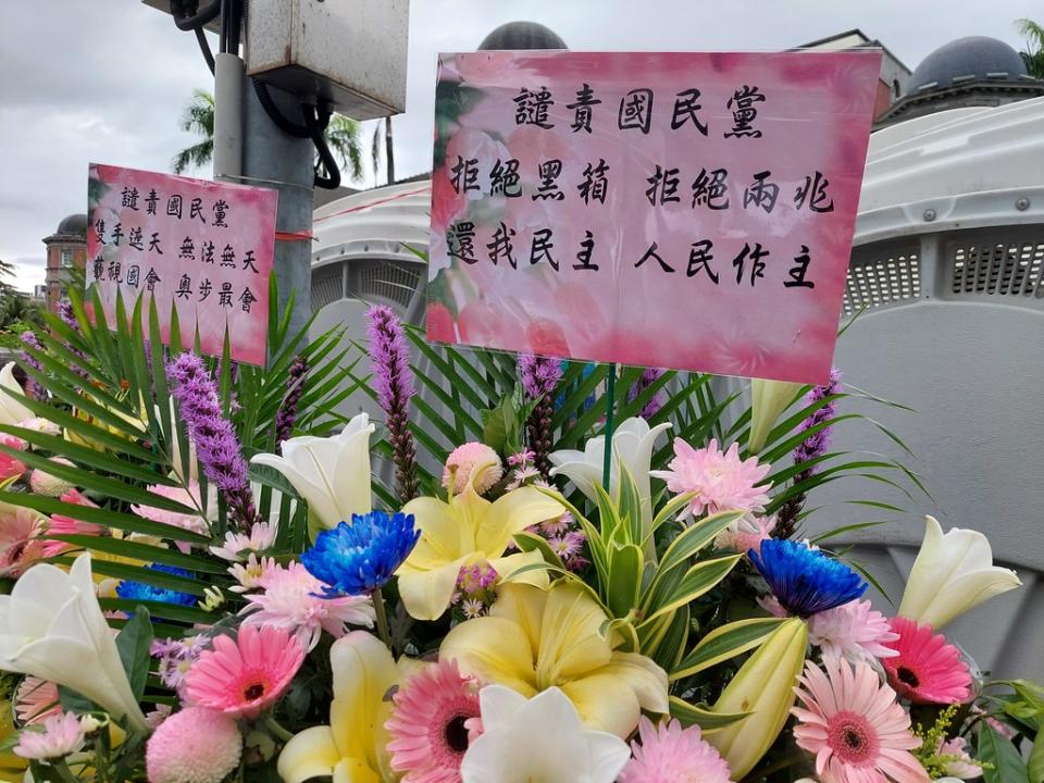 民眾在場外留下花籃，寫著「拒絕兩兆」。「花東三案」因估算經費龐大，又被民眾稱為「錢坑法案」或「兩兆法案」。攝影：陳昭宏