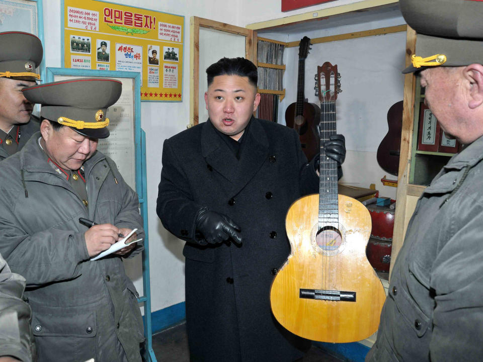 North Korean leader Kim Jong-Un holds a guitar during a visit to a military unit on the Wolnae Islet Defence Detachment in 2013: REUTERS