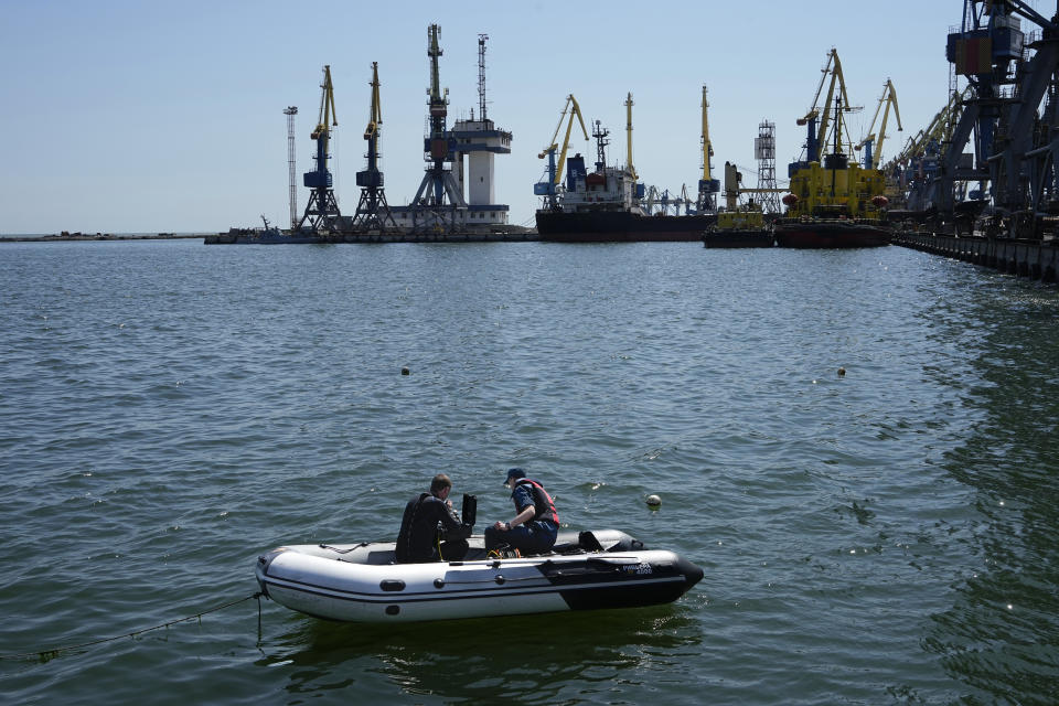 FILE - Servicemen of Donetsk People's Republic Emergency Ministry work to defuse a Ukrainian mine in an area of the Mariupol Sea Port in Mariupol, in territory under the government of the Donetsk People's Republic, eastern Ukraine, on April 29, 2022. This photo was taken during a trip organized by the Russian Ministry of Defense. The European Commission is proposing to help Ukraine move its critical grain supplies to parts of the world at risk of food insecurity. The plan released Thursday, May 12, 2022, by the European Union’s executive arm urges rail, road and river routes to get around a Russian blockade of Black Sea ports. (AP Photo)