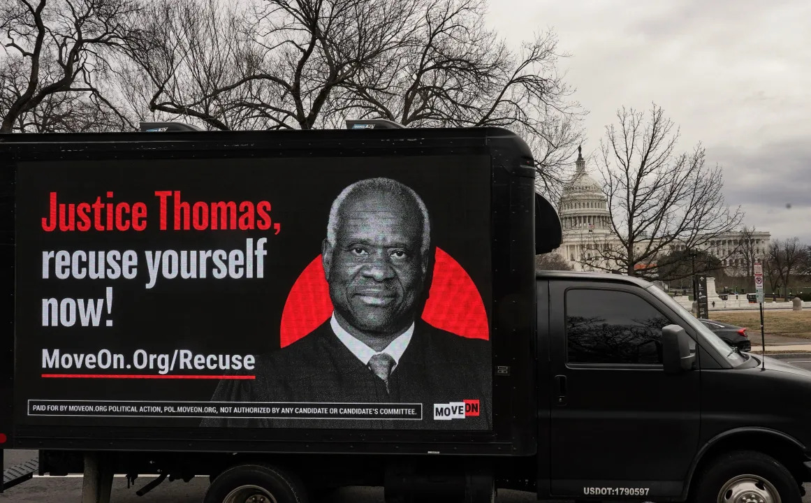 A billboard calling for Justice Clarence Thomas to recuse himself reads: Justice Thomas, recuse yourself now!