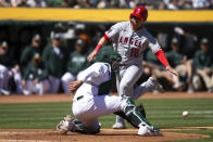 Los Angeles Angels' Jake Lamb (18) eludes a tag-attempt by Oakland Athletics catcher Shea Langeliers, left, to score on a single by Gio Urshela during the third inning of a baseball game, Saturday, April 1, 2023, in Oakland, Calif. (AP Photo/D. Ross Cameron)