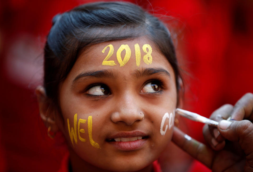 A schoolgirl reacts as she gets her face painted during New Year's celebrations at her school in Ahmedabad, India. (Photo: Amit Dave / Reuters)