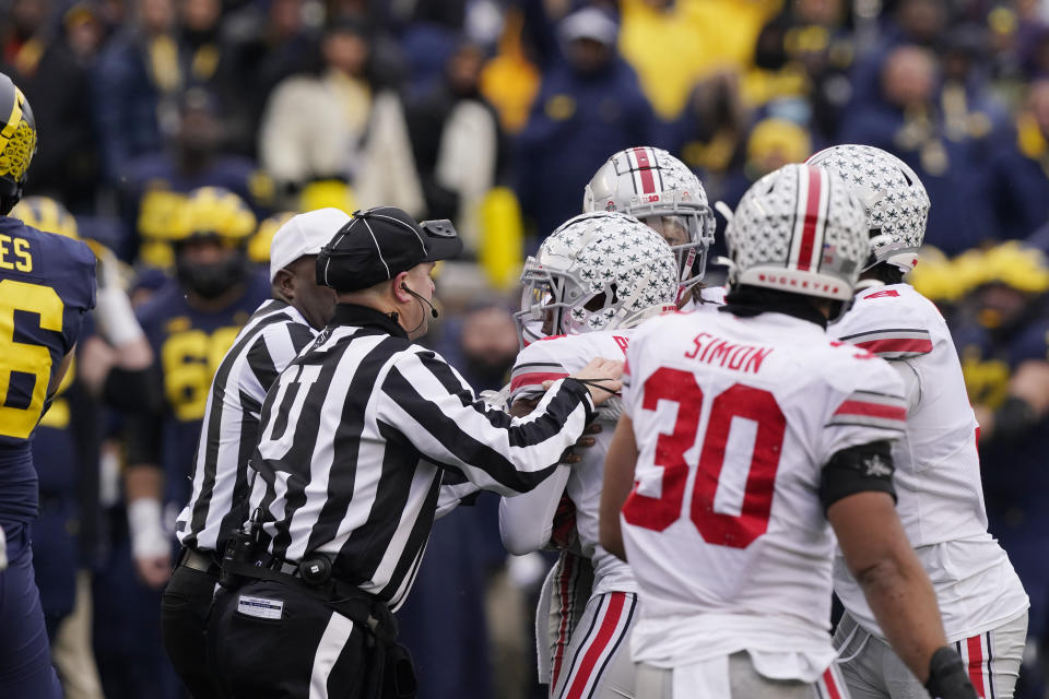 Referees separate Ohio State players from the Michigan players during the second half of an NCAA college football game, Saturday, Nov. 27, 2021, in Ann Arbor, Mich. (AP Photo/Carlos Osorio)