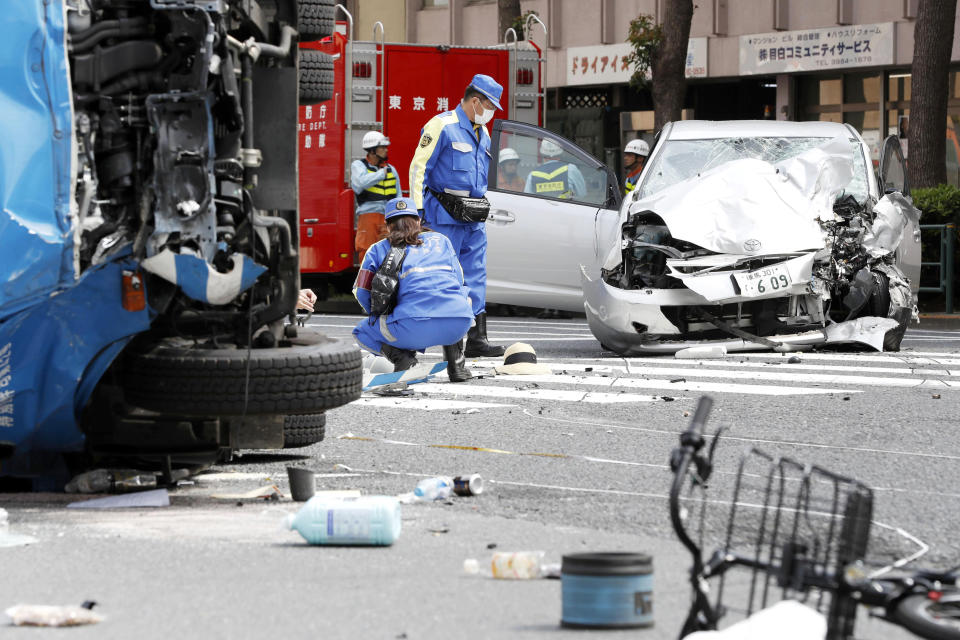 FILE - In this April 19, 2019, file photo, police officers inspect the scene of a car accident in Tokyo. The Tokyo District Court on Thursday, Sept. 2, 2021, sentenced Kozo Iizuka, a 90-year-old former top bureaucrat, to five years in prison in the fatal car accident on a busy Tokyo street, killing a 3-year-old girl and her mother in a high-profile case in a fast-aging country where elderly driving has become a major safety concern. (Shinji Kita/Kyodo News via AP, File)