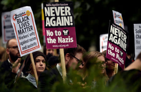 Demonstrators hold placards during an anti-fascist protest outside the U.S Embassy in London, Britain, August 14, 2017. REUTERS/Hannah McKay