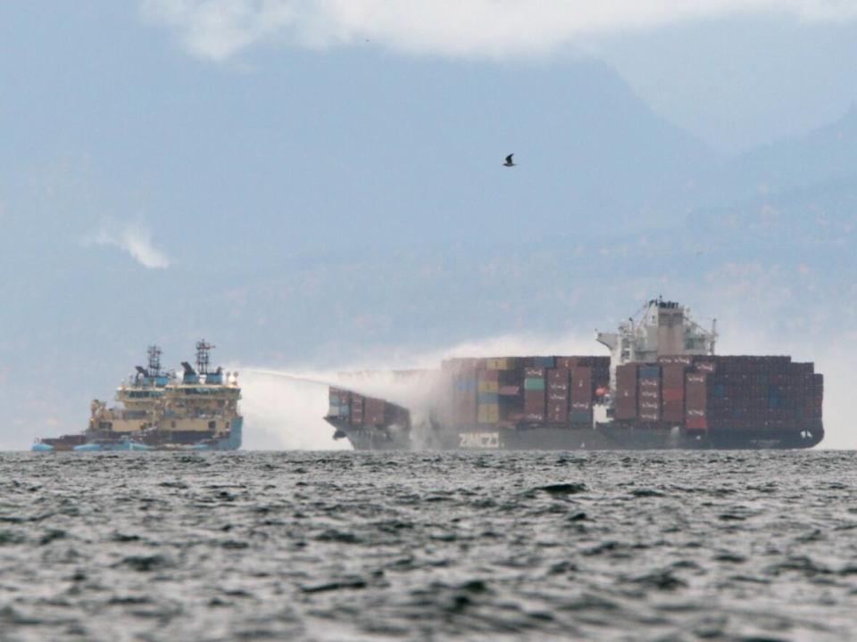 Ships work to control a fire onboard the MV Zim Kingston about eight kilometres from the shore in Victoria on Oct. 24, 2021. The container ship caught fire on Saturday and 16 crew members were evacuated and brought to Breakwater District. (Chad Hipolito/The Canadian Press - image credit)