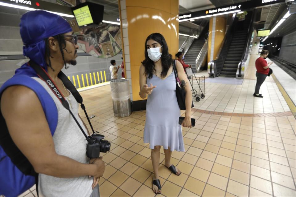 Two people speaking on a train platform