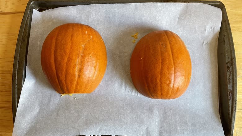 Pumpkin halves on a baking sheet