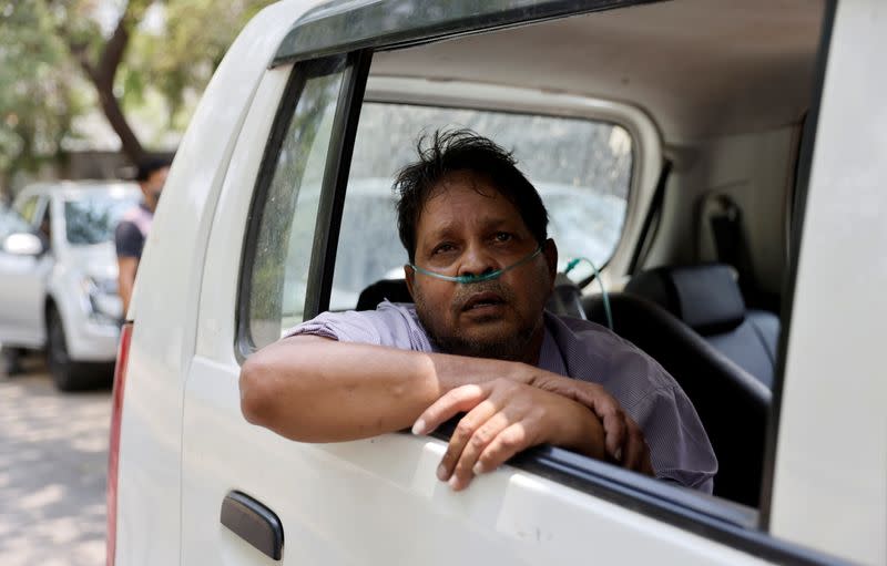 Vijay Gupta with breathing problem sits inside a car as he waits to get admission at a COVID-19 hospital for treatment, in Ahmedabad