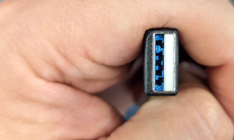 Closeup of the plug of a USB controller accessory with pieces of blue inside the part of the plug meant to be hollow.